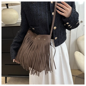Detail shot of vintage dark brown suede tote bag featuring long fringes and metal rings
