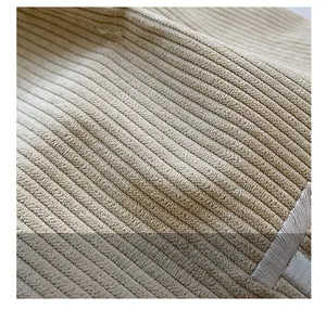Macro shot of corduroy fabric texture and fine stitching on the beige tote bag