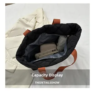 Close-up of black quilted tote bag interior showing large capacity for umbrella and phone