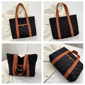 Quilted black tote bag details featuring orange straps and functional metal snap pocket