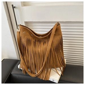 Detail of a brown suede Hobo bag with long fringe tassels and gold metal hardware
