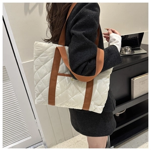 Detailed quilted oxford tote bag in beige with contrast brown straps shown on a model