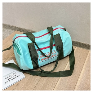 Detail der mintgrünen wasserdichten Reisetasche mit roten Reißverschlüssen und Griffen
