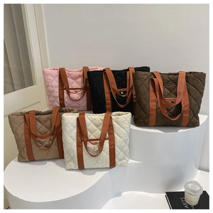 Detailed display of quilted tote bags in five colors with orange woven straps