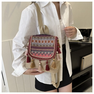 Detailaufnahme eines Boho-Canvas-Rucksacks mit geometrischer Stickerei und bunten Quasten