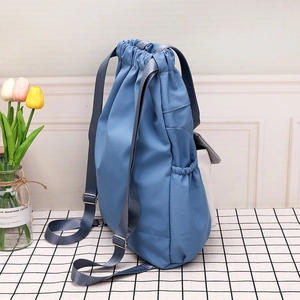Detail view of contrast nylon drawstring bucket bag with side pocket and tulip decor