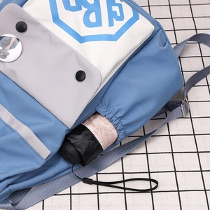 Detail of drawstring backpack side pocket holding a floral umbrella with a blue design
