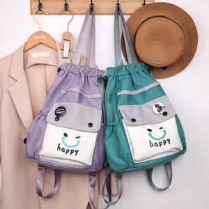 Detail of vibrant color-block drawstring backpack with happy face print and handles