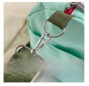 Detail der mintgrünen Nylon-Sporttasche mit abnehmbarem olivgrünem Gurt und silbernem Haken