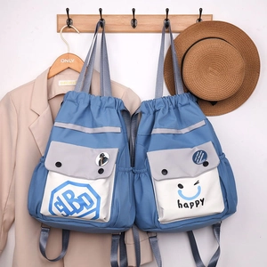 Detail of blue nylon drawstring bucket backpack with happy smiley and BD badge design