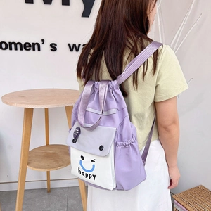 Detail of purple drawstring backpack with white smiley face pocket and adjustable straps