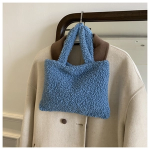 Close-up of light blue sherpa fleece tote bag with soft curly faux fur texture details