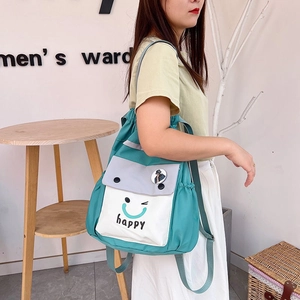 Detail of teal nylon drawstring bucket backpack with happy face print and side pocket