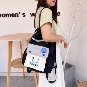 Detail of color-block nylon drawstring backpack with happy smiley print and fashion label
