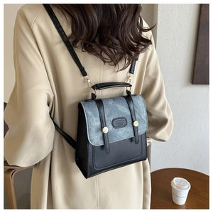 Detail eines zweifarbigen Mini-Retro-Lederrucksacks mit schicken Goldnieten und Riemen