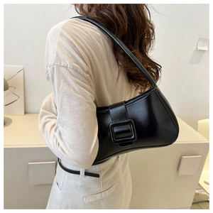 Detalle de bolso bajo el brazo negro minimalista con hebilla cuadrada de cuero vintage