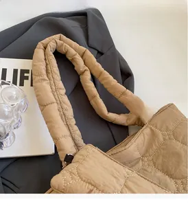 Close-up of khaki quilted tote bag featuring reinforced handles and diamond stitching