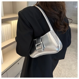 Detalle de bolso medialuna plateado metalizado con correa ancha y hebilla cuadrada