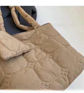 Detail shot of the quilted stitching and soft khaki fabric texture on the casual tote bag