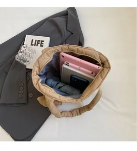 Beige quilted tote bag interior view showcasing large capacity for tablet and umbrella