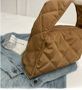 Detail of caramel brown quilted tote bag with large diamond stitching and smooth zipper