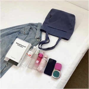 Macro shot of large capacity navy canvas tote bag interior with various daily essentials