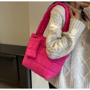 Detail of quilted bright pink tote bag featuring a matching mini detachable pouch charm