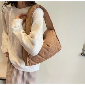 Detail of khaki quilted shoulder bag showing large rhombus stitching and soft texture