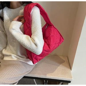 Quilted fuchsia tote bag on model showing large capacity and vibrant nylon fabric detail