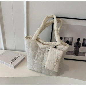 Detailed macro view of white quilted tote bag featuring a circular petal pattern texture