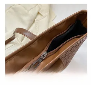 Detailaufnahme des glatten Reißverschlusses und der Webstruktur der braunen Tasche
