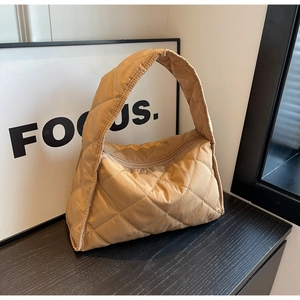 Close-up of khaki quilted puffer tote bag with diamond stitching and smooth top zipper