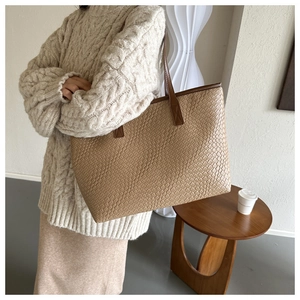 Braune Shopper-Tasche mit Krokodilprägung kombiniert mit einem cremefarbenen Strickpullover