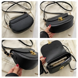 Detail of black leather saddle bag with gold buckle showing interior storage capacity