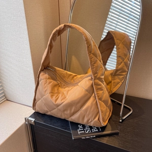 Brown quilted nylon tote bag with rhombus pattern and wide shoulder strap in chic interior setting