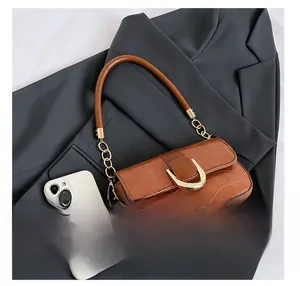 Größenvergleich der braunen Baguette-Tasche mit Kroko-Prägung und Smartphone