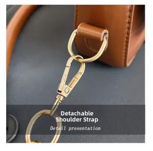 Detailaufnahme der braunen Ledertasche mit abnehmbarem Schultergurthaken aus Goldmetall
