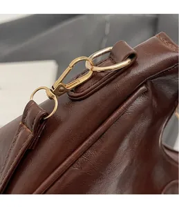 Close-up of premium dark brown leather texture and elegant gold metallic hardware hook