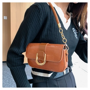 Detailansicht der braunen Mini-Tasche aus Kroko-Imitat mit markanter goldener U-Schnalle