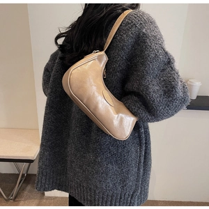 Chic light brown hobo bag with zip closure styled on model with knit sweater