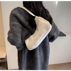 Detail of white leather crescent hobo bag with embossed letters and wide shoulder strap