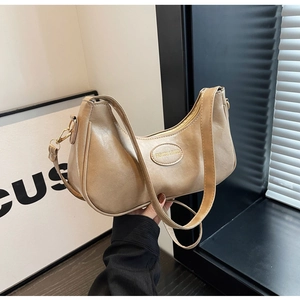 Detail of khaki crescent hobo bag with Fashion & Bags embossed logo and faux leather texture