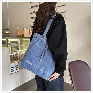 Detailed texture of denim tote bag with street style typography in coffee shop setting