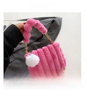 Detail of pink faux fur handbag showing plush texture and metallic gold chain strap
