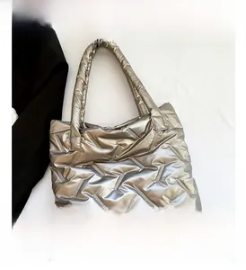 Détail du sac cabas matelassé argenté avec finition métallique sur une veste de costume