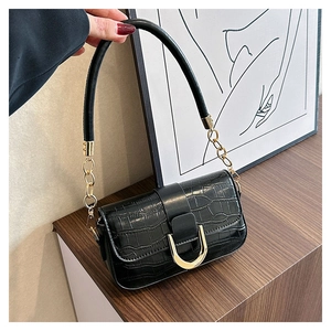 Details der schwarzen Kroko-Handtasche mit goldener Hufeisenschnalle und Kette