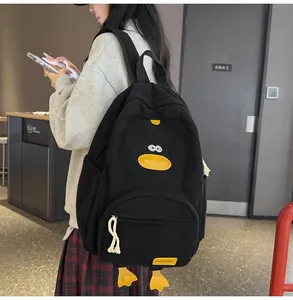 Detail of black corduroy backpack with cute cartoon duck features and textured fabric