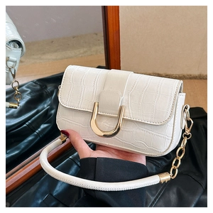 Detailansicht der weißen Handtasche mit Kroko-Prägung und goldener U-förmiger Schnalle
