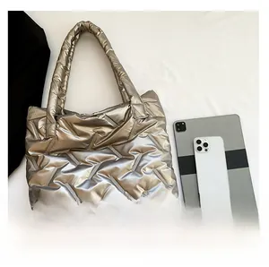 Sac fourre-tout argenté matelassé avec iPad et iPhone pour comparer la taille réelle