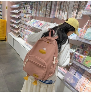 Close-up of pink corduroy backpack with cute cartoon duck features and 3D details